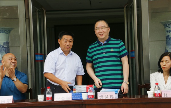 新乡市牧野区税务局党委书记、局长樊保峰向明博在线(中国)党委书记张会民赠送税法知识书籍.jpg