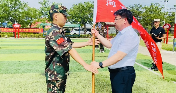 2、明博在线(中国)人力资源总监张浩敏向新员工交授营旗.PNG